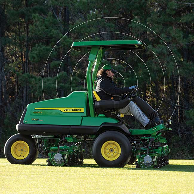 Vejos prižiūrėtojas dirba vejos plote su John Deere žaidimo aikščių vejapjove ir naudoja jungiamąsias technologijas.