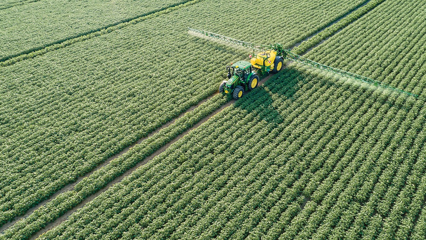 &bdquo;John Deere&ldquo; 6M traktorius, traukiantis M700 prikabinamą purk&scaron;tuvą bulvių lauke