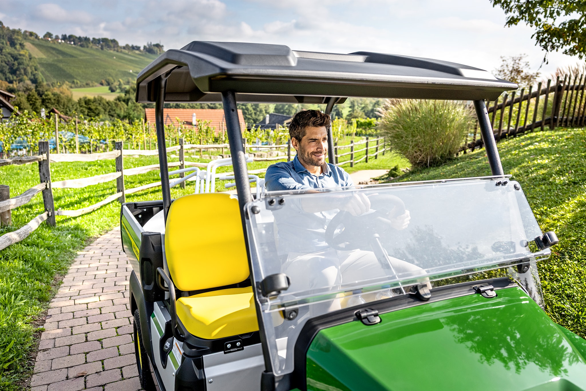 "John Deere Gator GS" salono su geltonomis sėdynėmis ir vairu vaizdas iš arti "John Deere Gator GS" salono su geltonomis sėdynėmis ir vairu vaizdas iš arti