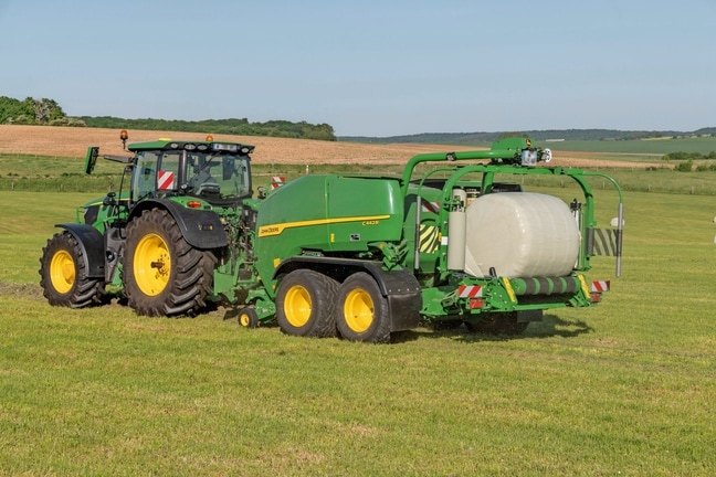 John Deere 6R 185 velkamas John Deere" C442R presas-vyniotuvas, rišantis didelio tankio siloso ryšulius