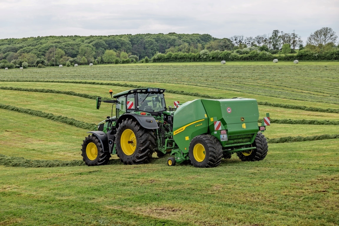 John Deere 6M traktoriaus velkamas "John Deere" F442R ryšulių presas kalvotoje pievoje